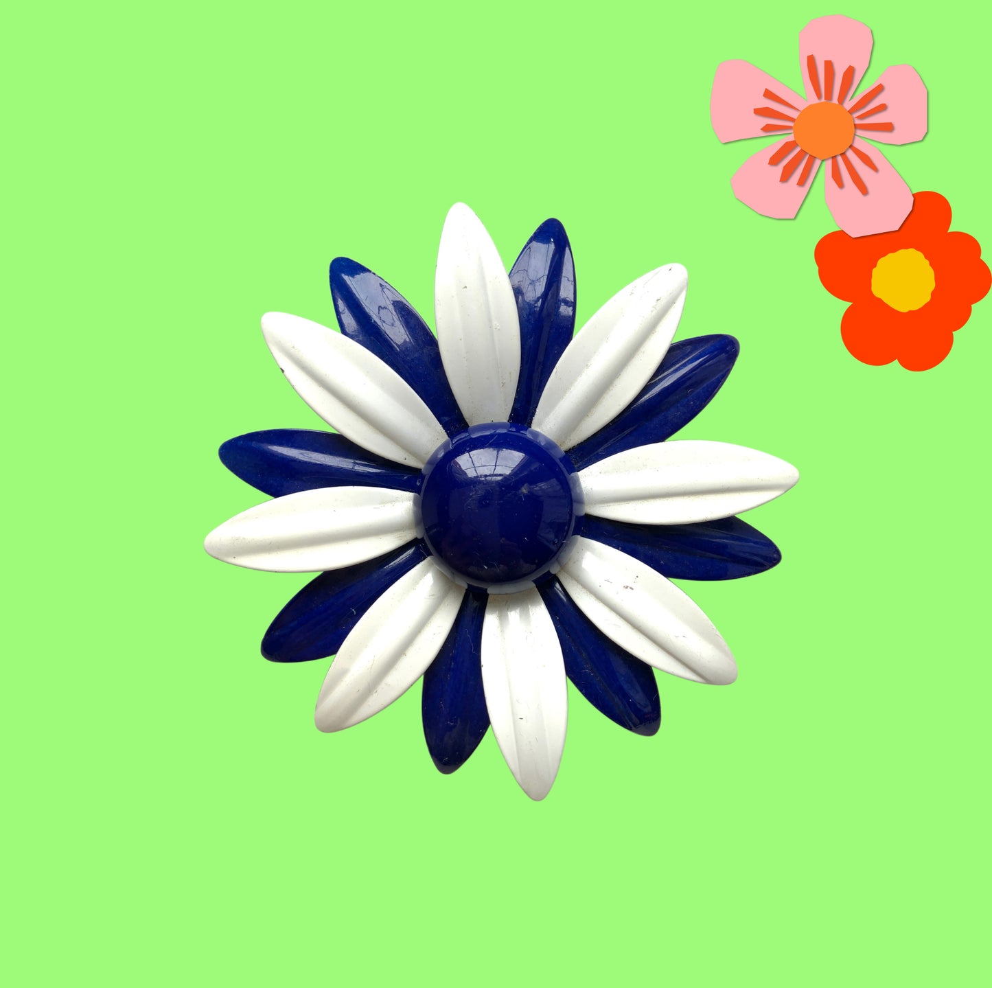 An oversized flower brooch in navy blue and white enamel. ネイビーブルーとホワイトのエナメルを使用した、大ぶりのフラワーブローチ。