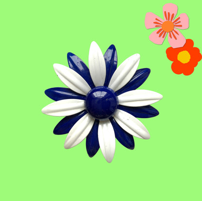 An oversized flower brooch in navy blue and white enamel. ネイビーブルーとホワイトのエナメルを使用した、大ぶりのフラワーブローチ。
