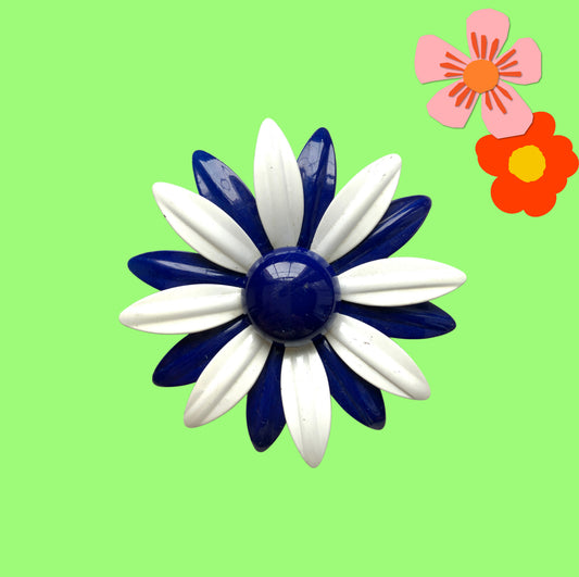 An oversized flower brooch in navy blue and white enamel. ネイビーブルーとホワイトのエナメルを使用した、大ぶりのフラワーブローチ。