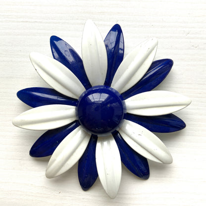 An oversized flower brooch in navy blue and white enamel. ネイビーブルーとホワイトのエナメルを使用した、大ぶりのフラワーブローチ。