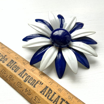 An oversized flower brooch in navy blue and white enamel. ネイビーブルーとホワイトのエナメルを使用した、大ぶりのフラワーブローチ。