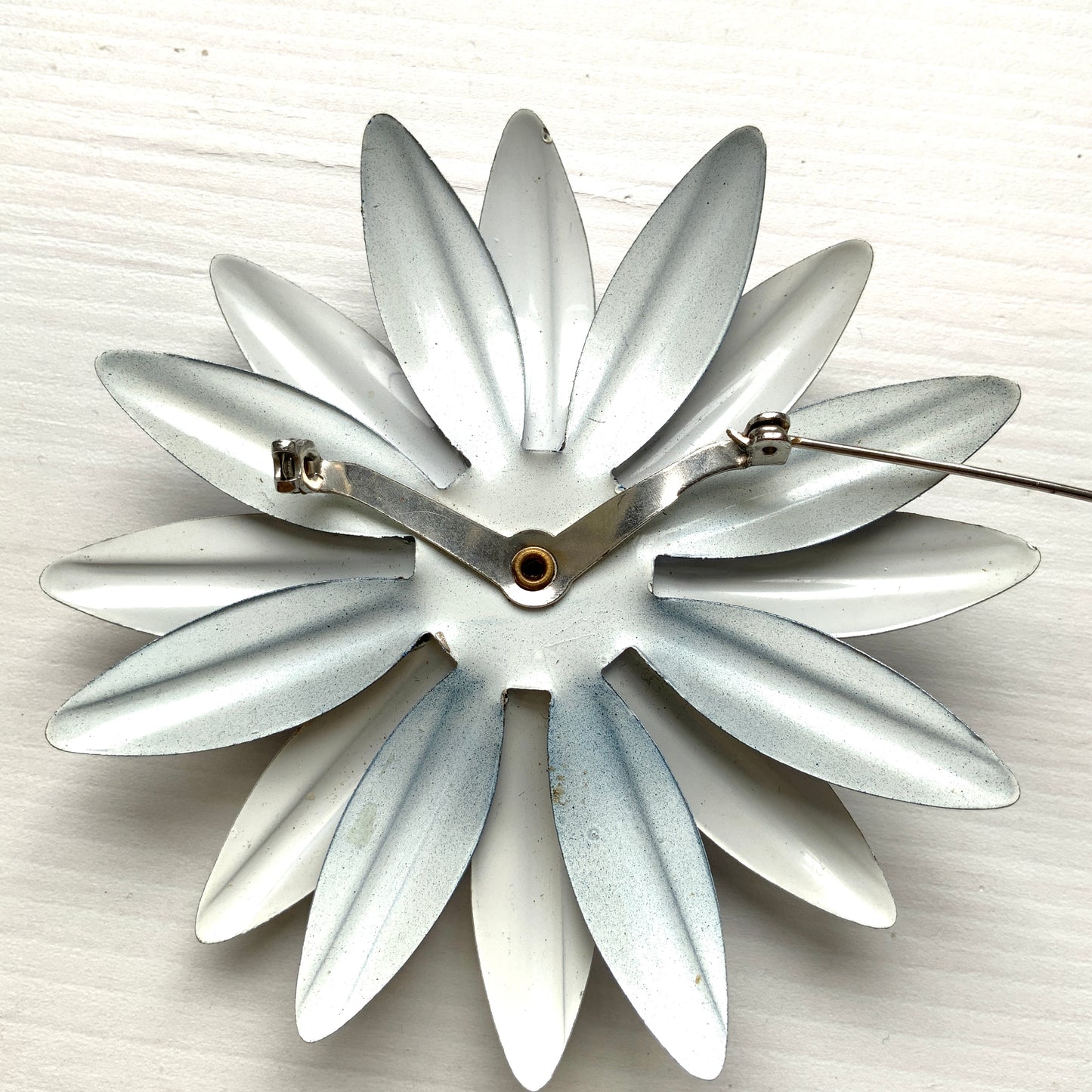 An oversized flower brooch in navy blue and white enamel. ネイビーブルーとホワイトのエナメルを使用した、大ぶりのフラワーブローチ。
