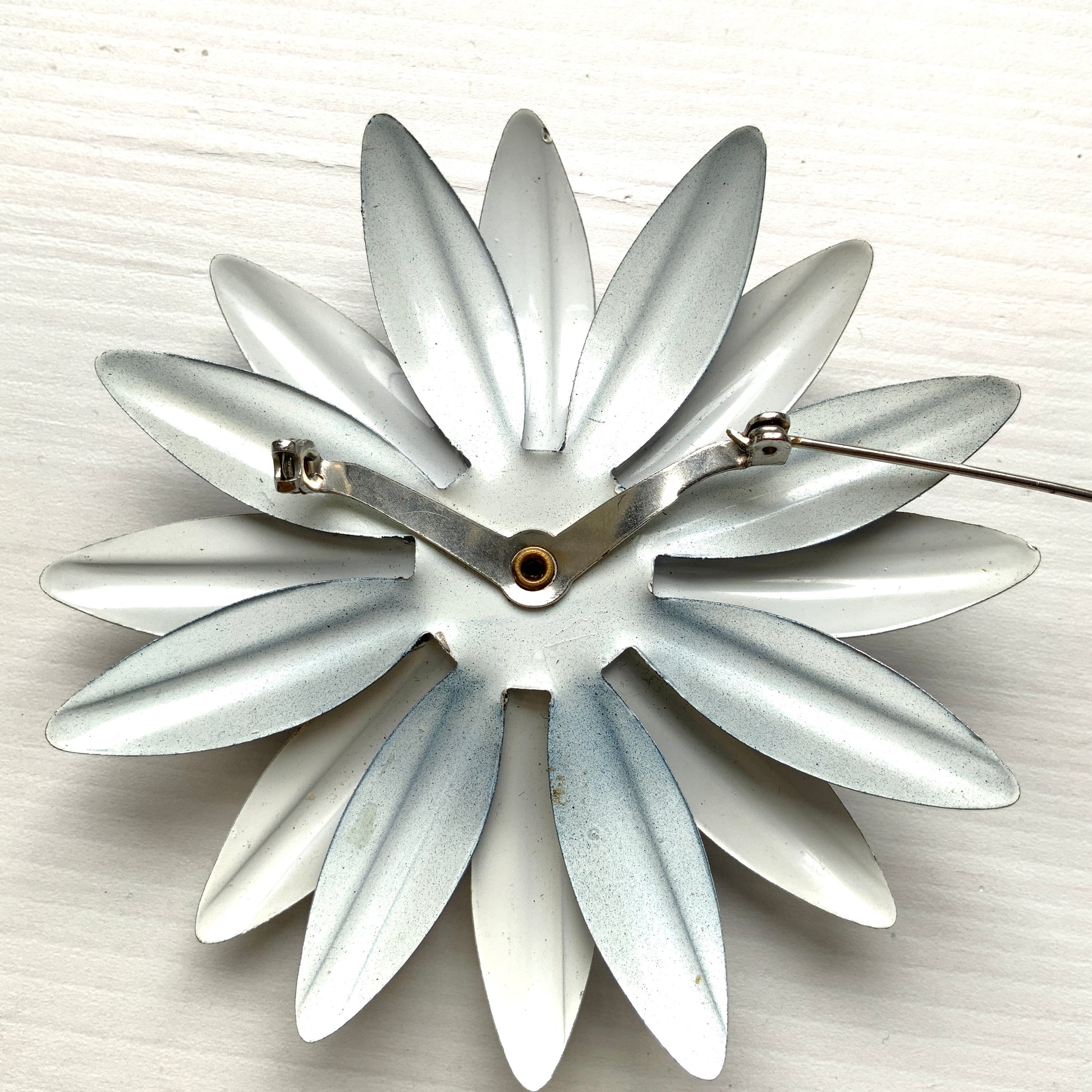 An oversized flower brooch in navy blue and white enamel. ネイビーブルーとホワイトのエナメルを使用した、大ぶりのフラワーブローチ。