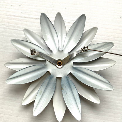 An oversized flower brooch in navy blue and white enamel. ネイビーブルーとホワイトのエナメルを使用した、大ぶりのフラワーブローチ。