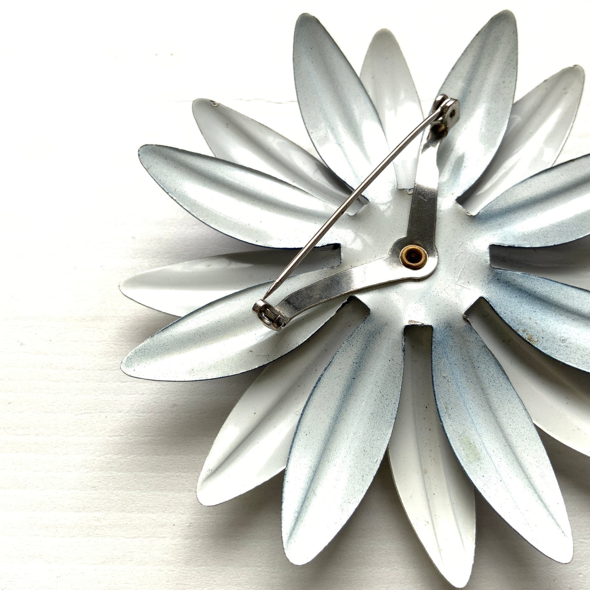 An oversized flower brooch in navy blue and white enamel. ネイビーブルーとホワイトのエナメルを使用した、大ぶりのフラワーブローチ。