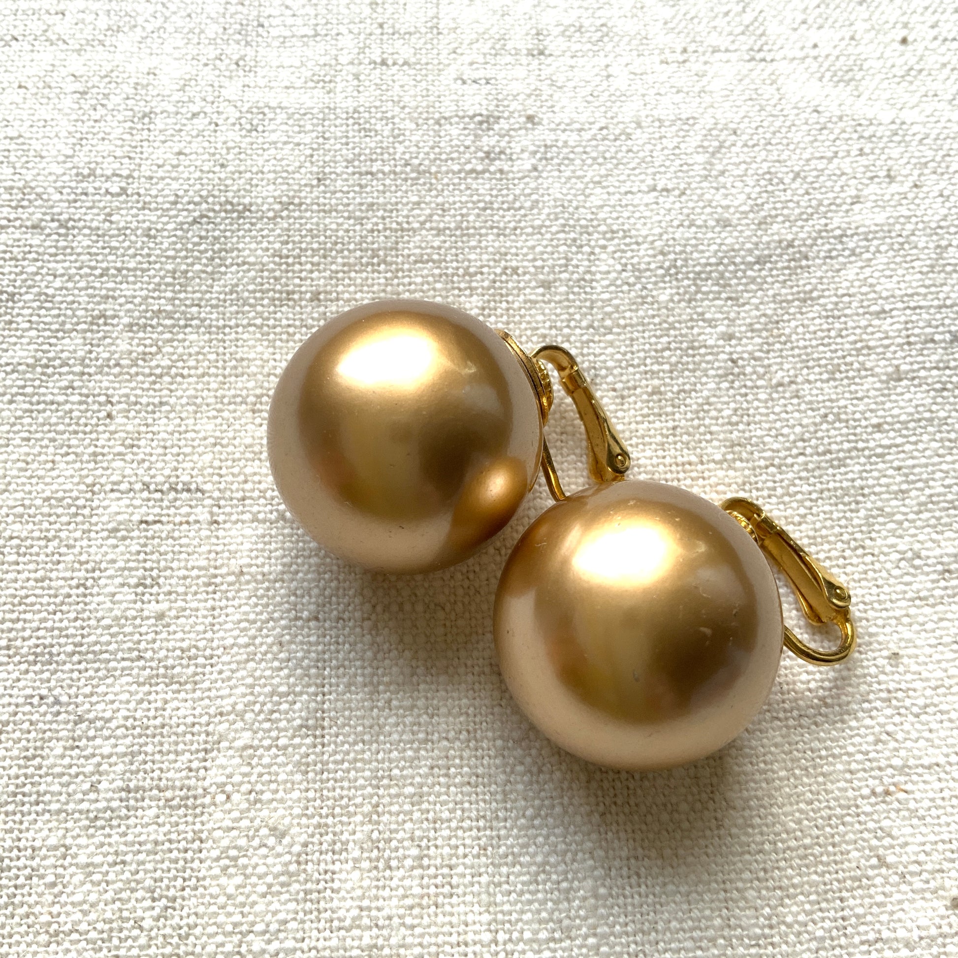 Simple gold-tone clip-on earrings featuring large faux pearls. ゴールドトーンの大ぶりフェイクパールが印象的な、シンプルなクリップイヤリング。 