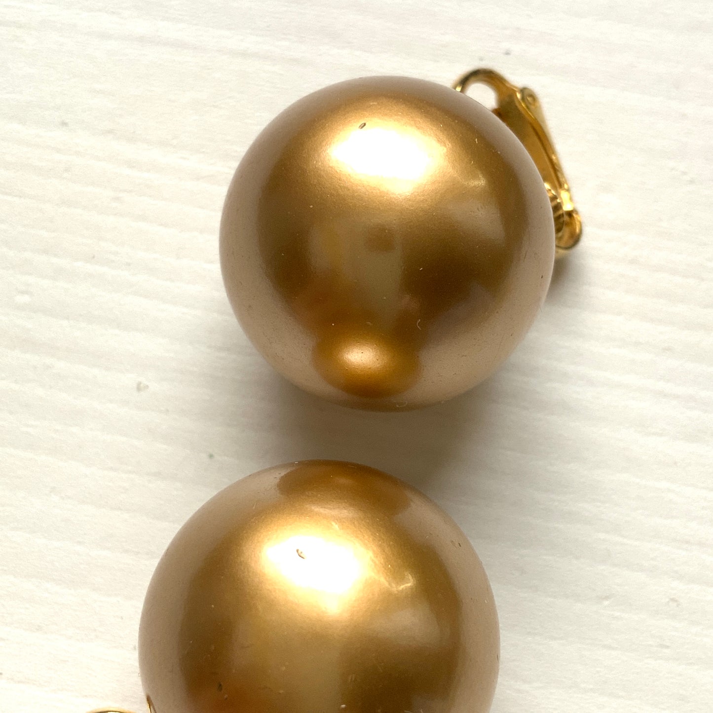 Simple gold-tone clip-on earrings featuring large faux pearls. ゴールドトーンの大ぶりフェイクパールが印象的な、シンプルなクリップイヤリング。 