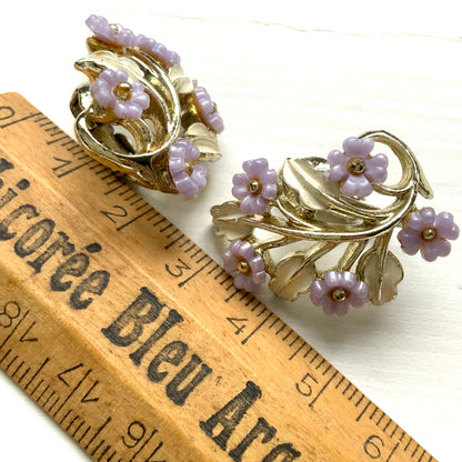 Charming clip-on earrings with pale purple blossoms adorning white enameled leaves. 白いエナメルの葉っぱに、かわいらしい薄紫のお花が咲いたクリップイヤリング。 