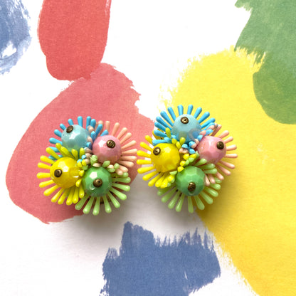 Clip-on earrings featuring clusters of soft plastic flowers in colourful candy hues. カラフルなキャンディーカラーのソフトプラスチックのお花が集まったクリップイヤリング。