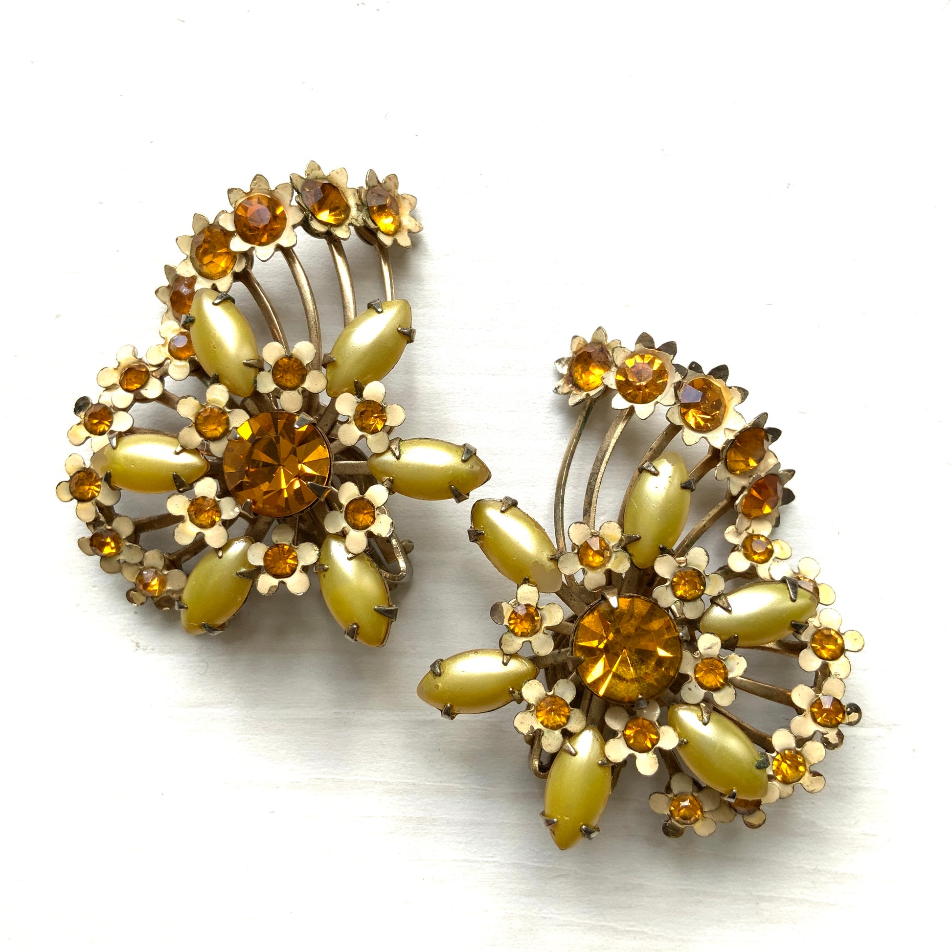 A burst of vitamin colour – these 1960s flower earrings are full of retro charm and energy. アンバーラインストーンとエナメルの小花が散りばめられた、華やかなクリップイヤリング