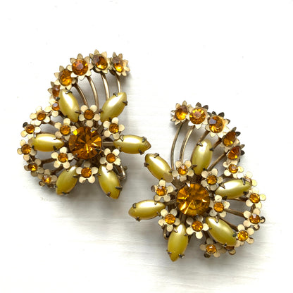 A burst of vitamin colour – these 1960s flower earrings are full of retro charm and energy. アンバーラインストーンとエナメルの小花が散りばめられた、華やかなクリップイヤリング