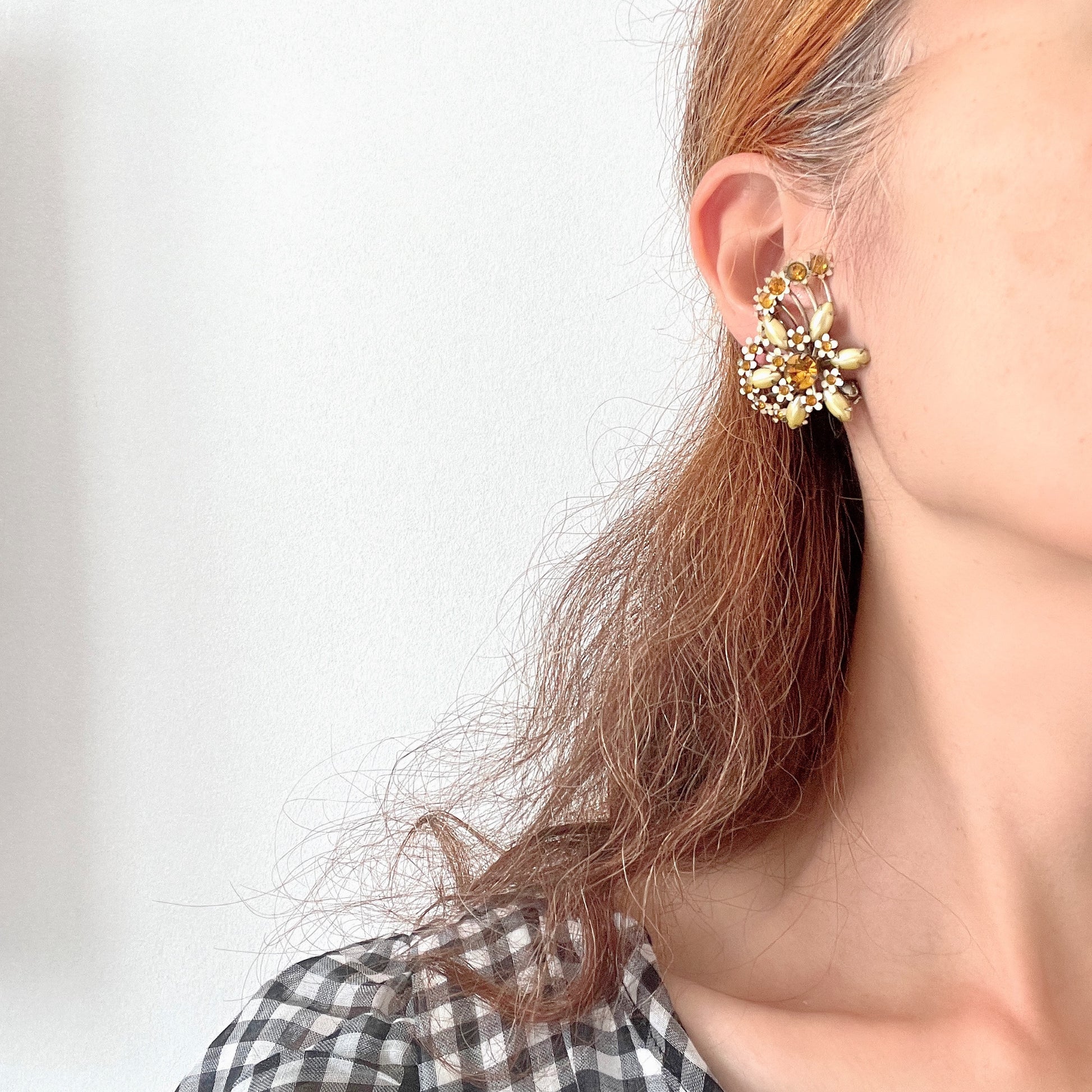 A burst of vitamin colour – these 1960s flower earrings are full of retro charm and energy. アンバーラインストーンとエナメルの小花が散りばめられた、華やかなクリップイヤリング