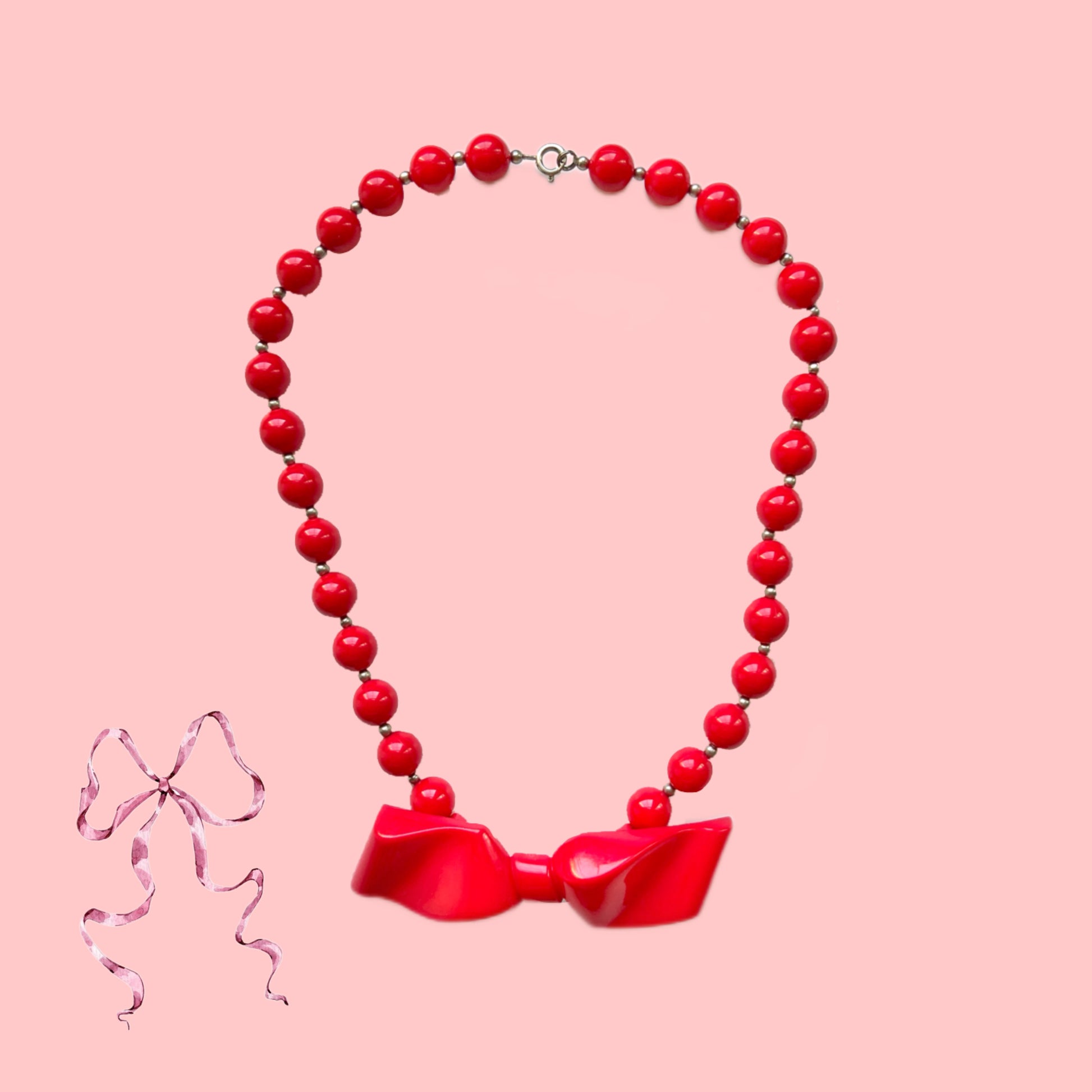 Vintage necklace featuring bright red plastic beads and a bow motif. 鮮やかなプラスチックのレッドビーズとリボンモチーフのネックレス。