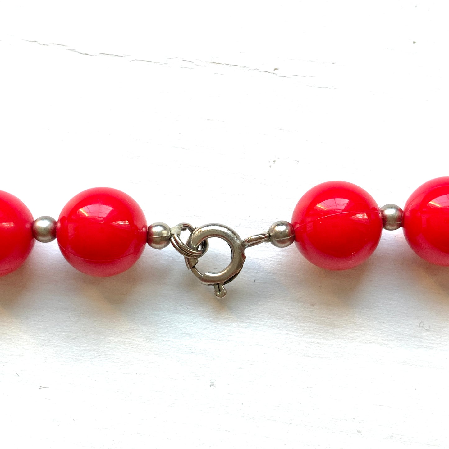 Vintage necklace featuring bright red plastic beads and a bow motif. 鮮やかなプラスチックのレッドビーズとリボンモチーフのネックレス。