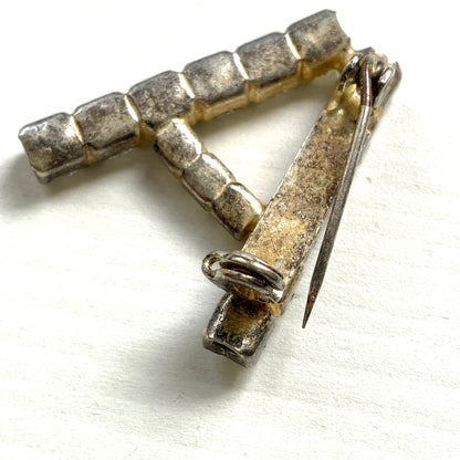 A brooch in the shape of the letter “A”, set with clear rhinestones. クリアラインストーンで”A”を象ったブローチ。 