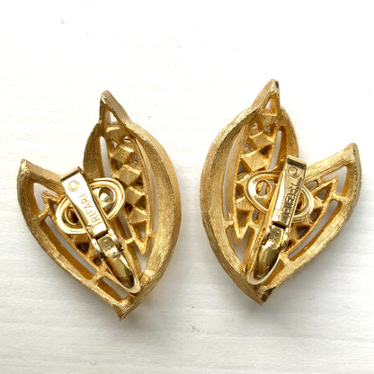Trifari clip-on earrings featuring slim, bamboo leaf–like gold-tone leaves adorned with a row of blue rhinestones. 笹の葉のようにスリムなゴールドトーンのリーフに、ブルーのラインストーンが並んだトリファリのイヤリング。 
