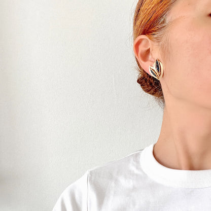 Trifari clip-on earrings featuring slim, bamboo leaf–like gold-tone leaves adorned with a row of blue rhinestones. 笹の葉のようにスリムなゴールドトーンのリーフに、ブルーのラインストーンが並んだトリファリのイヤリング。 