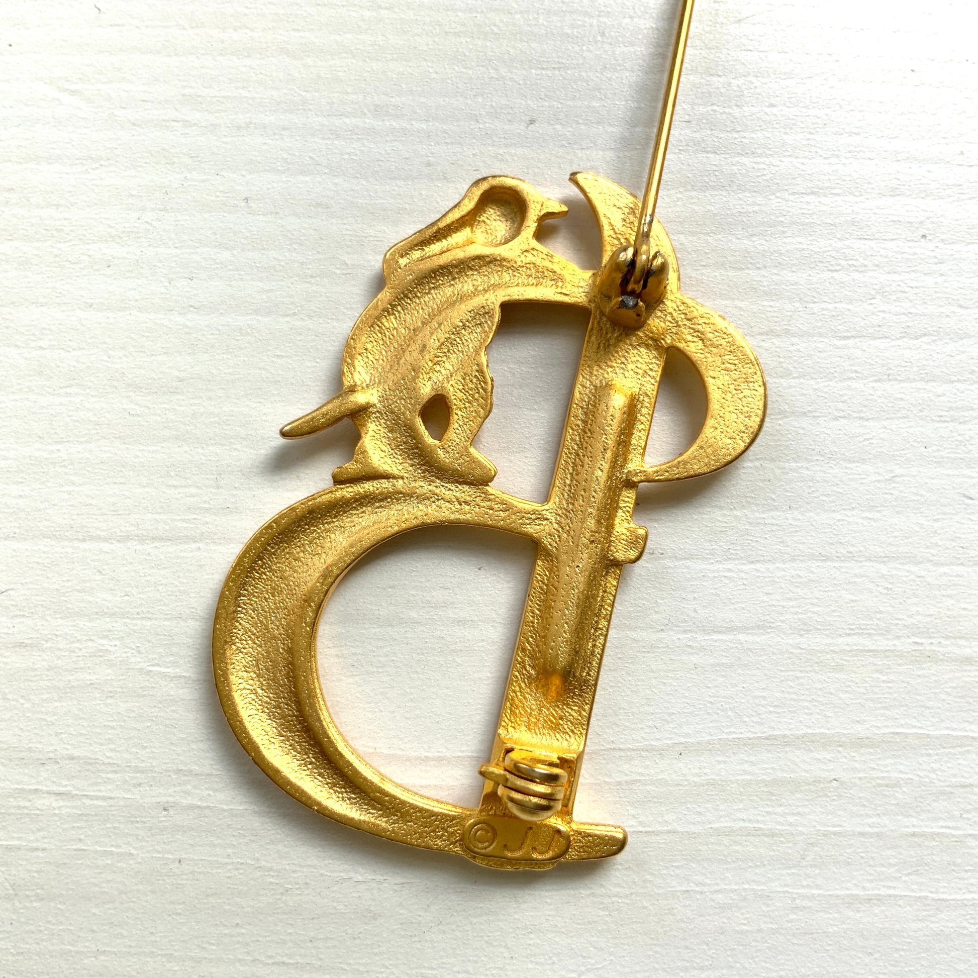 A gold-tone brooch in the shape of the letter “B”, with an adorable kitten clinging to it. かわいい子猫がつかまってる、ゴールドトーンのBのブローチ。
