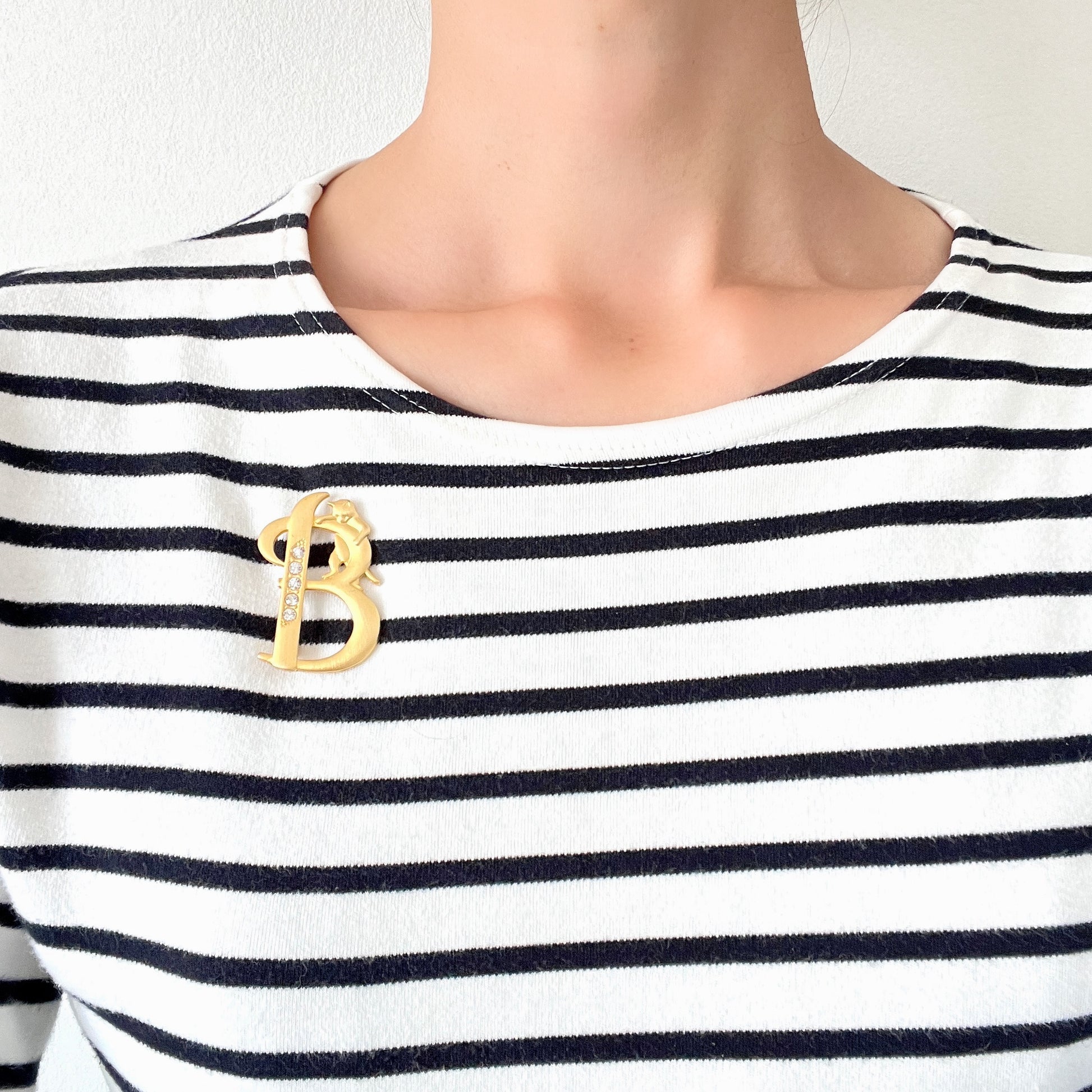 A gold-tone brooch in the shape of the letter “B”, with an adorable kitten clinging to it. かわいい子猫がつかまってる、ゴールドトーンのBのブローチ。