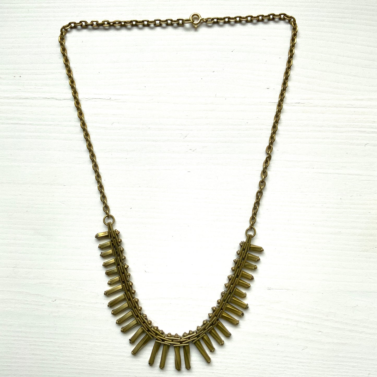 Gold-tone necklace featuring an eye-catching design of elongated twisted bars. 細長いゴールドパーツを並べたデザインが印象的な、ゴールドトーンのネックレス。