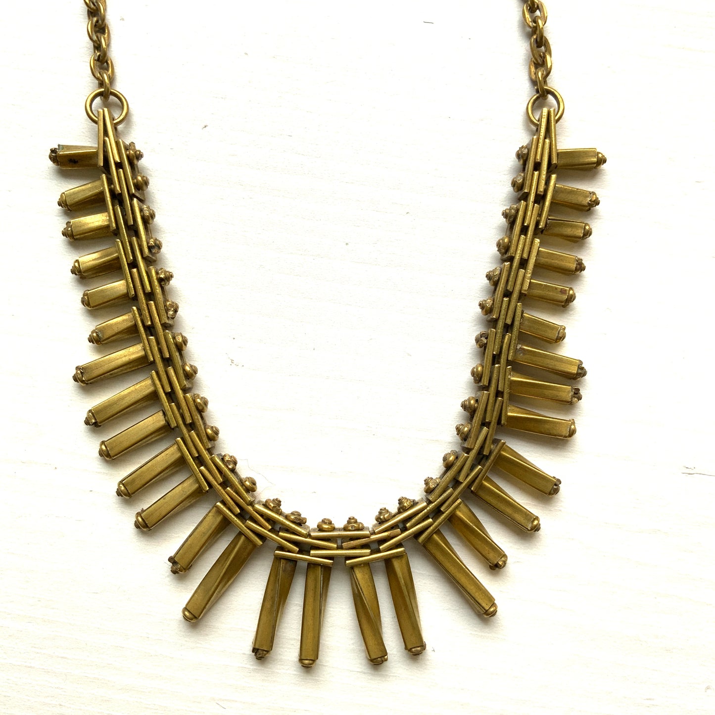 Gold-tone necklace featuring an eye-catching design of elongated twisted bars. 細長いゴールドパーツを並べたデザインが印象的な、ゴールドトーンのネックレス。