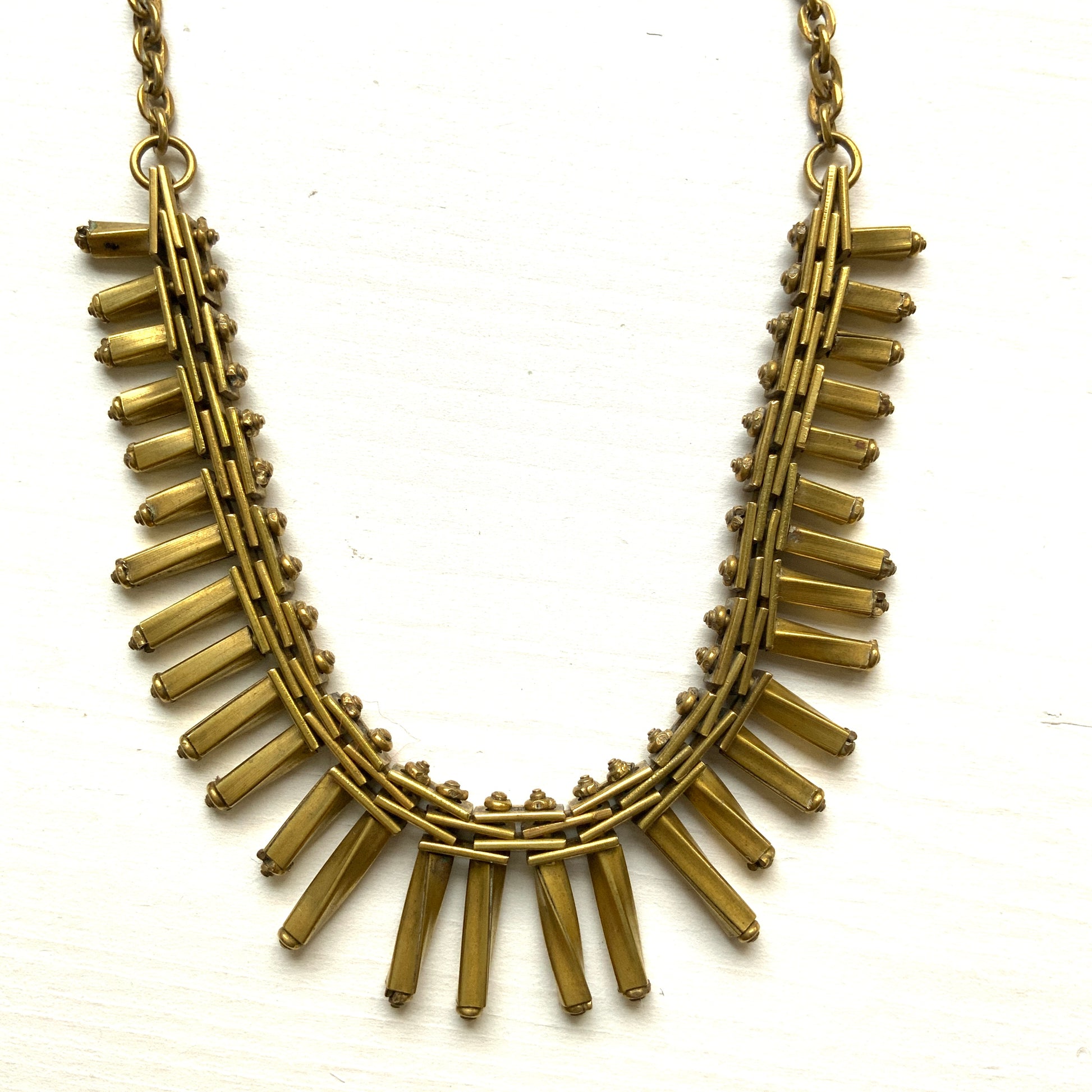 Gold-tone necklace featuring an eye-catching design of elongated twisted bars. 細長いゴールドパーツを並べたデザインが印象的な、ゴールドトーンのネックレス。