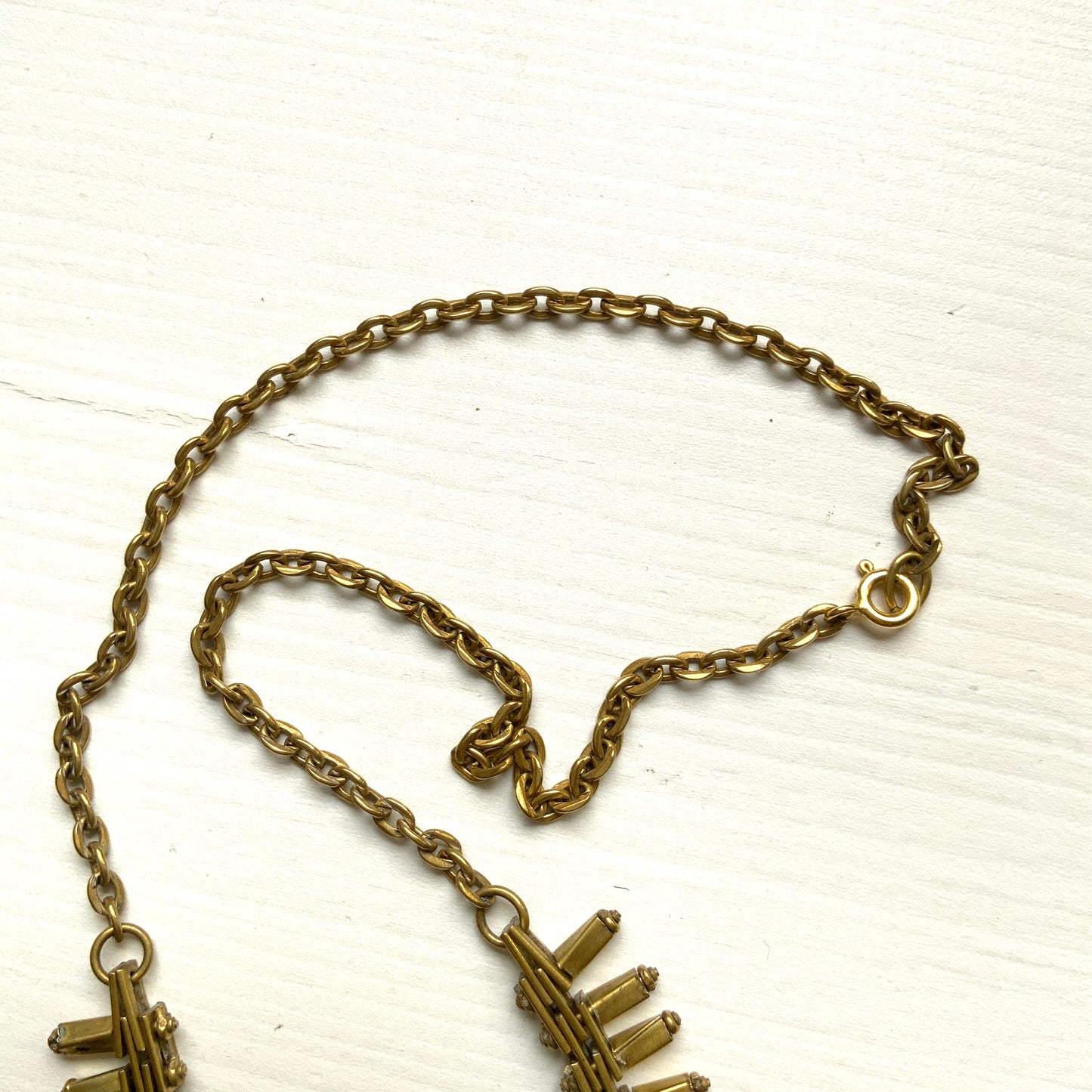 Gold-tone necklace featuring an eye-catching design of elongated twisted bars. 細長いゴールドパーツを並べたデザインが印象的な、ゴールドトーンのネックレス。
