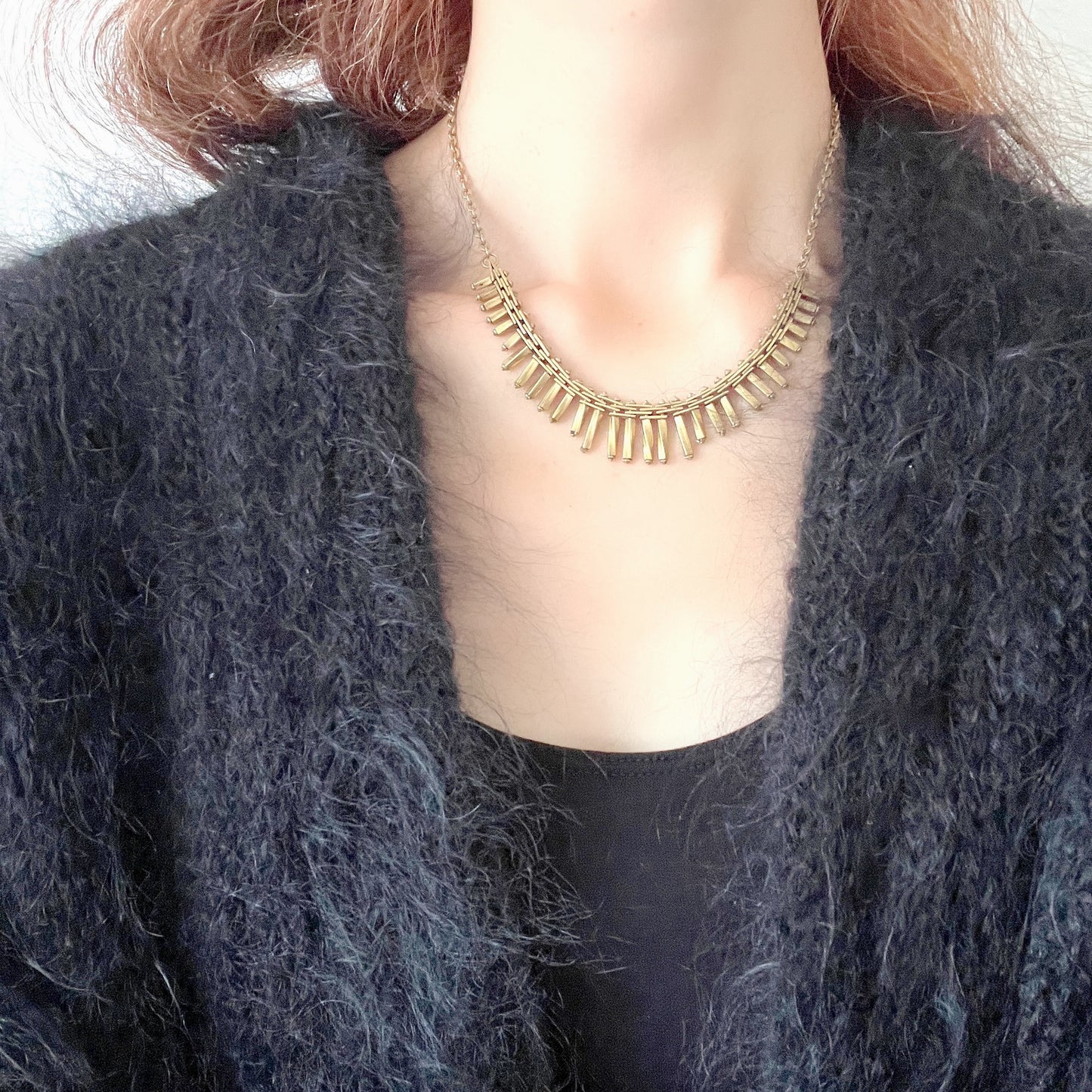 Gold-tone necklace featuring an eye-catching design of elongated twisted bars. 細長いゴールドパーツを並べたデザインが印象的な、ゴールドトーンのネックレス。