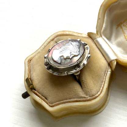 A silver ring with a cameo carved from mother of pearl, featuring the white layer carved into the profile of a lady against an iridescent grey-pink background. 白蝶貝（マザーオブパール）の白い層を彫り出し、グレー〜ピンクがかった虹色の層を背景にしたカメオのシルバーリング。 