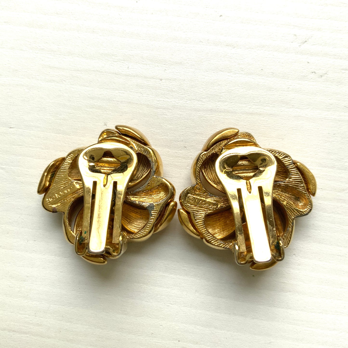 Gold-tone swirl clip-on earrings with curved, sculptural lines. 曲線的なスワールモチーフが印象的な、ゴールドトーンのクリップイヤリング。