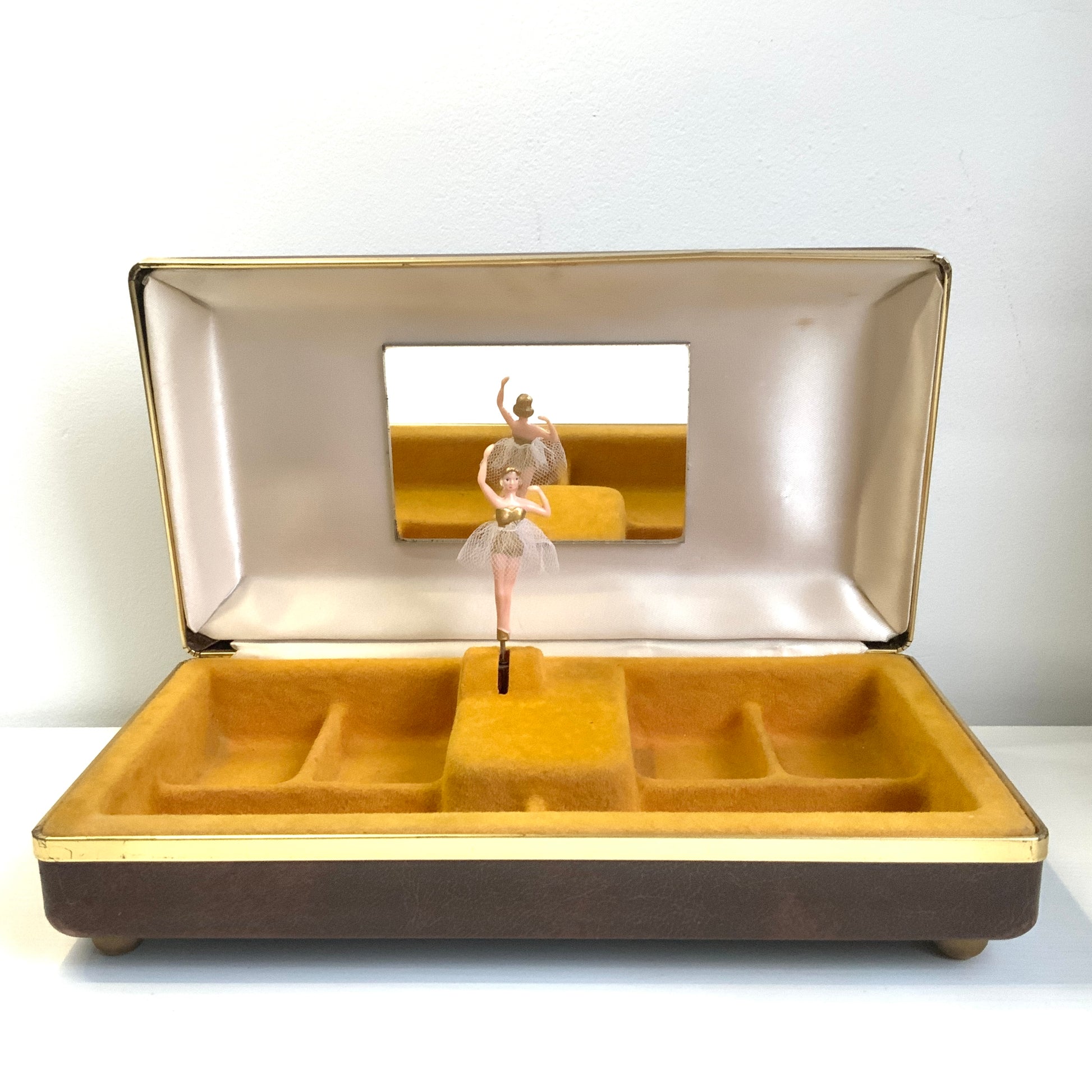 When the lid is opened, a ballerina dressed in a gold bodice and white tutu begins to spin gracefully to music, revealing a charming jewellery box with a built-in music box. 蓋を開けると、ゴールドにホワイトのチュチュをまとったバレリーナがくるくると踊り出す、オルゴール付きのジュエリーボックスです。 