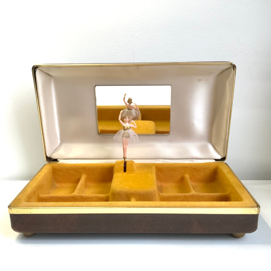 When the lid is opened, a ballerina dressed in a gold bodice and white tutu begins to spin gracefully to music, revealing a charming jewellery box with a built-in music box. 蓋を開けると、ゴールドにホワイトのチュチュをまとったバレリーナがくるくると踊り出す、オルゴール付きのジュエリーボックスです。 