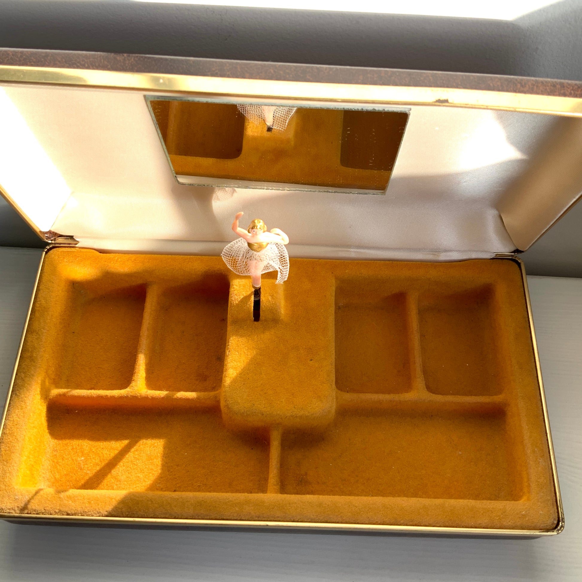 When the lid is opened, a ballerina dressed in a gold bodice and white tutu begins to spin gracefully to music, revealing a charming jewellery box with a built-in music box. 蓋を開けると、ゴールドにホワイトのチュチュをまとったバレリーナがくるくると踊り出す、オルゴール付きのジュエリーボックスです。 