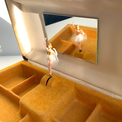 When the lid is opened, a ballerina dressed in a gold bodice and white tutu begins to spin gracefully to music, revealing a charming jewellery box with a built-in music box. 蓋を開けると、ゴールドにホワイトのチュチュをまとったバレリーナがくるくると踊り出す、オルゴール付きのジュエリーボックスです。 