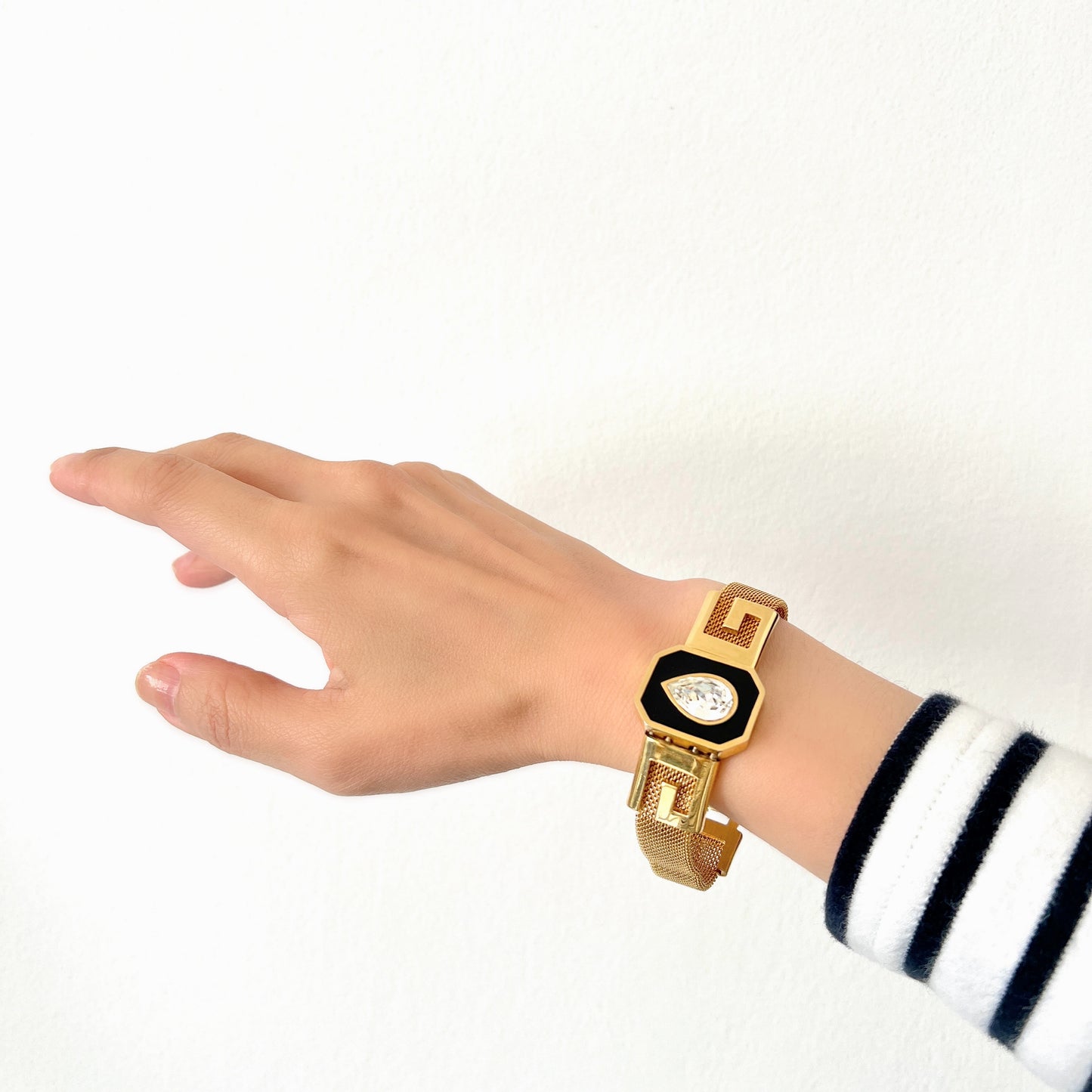 A Givenchy bracelet featuring black enamel, a teardrop of clear rhinestones, and the brand’s initial “G” logo. 黒のエナメルにクリアラインストーンのティアドロップ、そしてブランドロゴのイニシャル”G"が入った、ジバンシィのブレスレット。