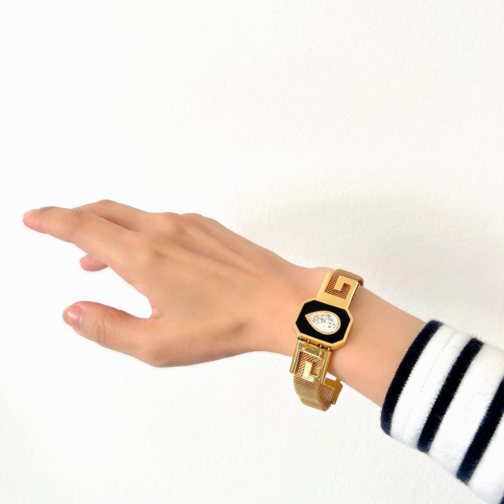 A Givenchy bracelet featuring black enamel, a teardrop of clear rhinestones, and the brand’s initial “G” logo. 黒のエナメルにクリアラインストーンのティアドロップ、そしてブランドロゴのイニシャル”G"が入った、ジバンシィのブレスレット。