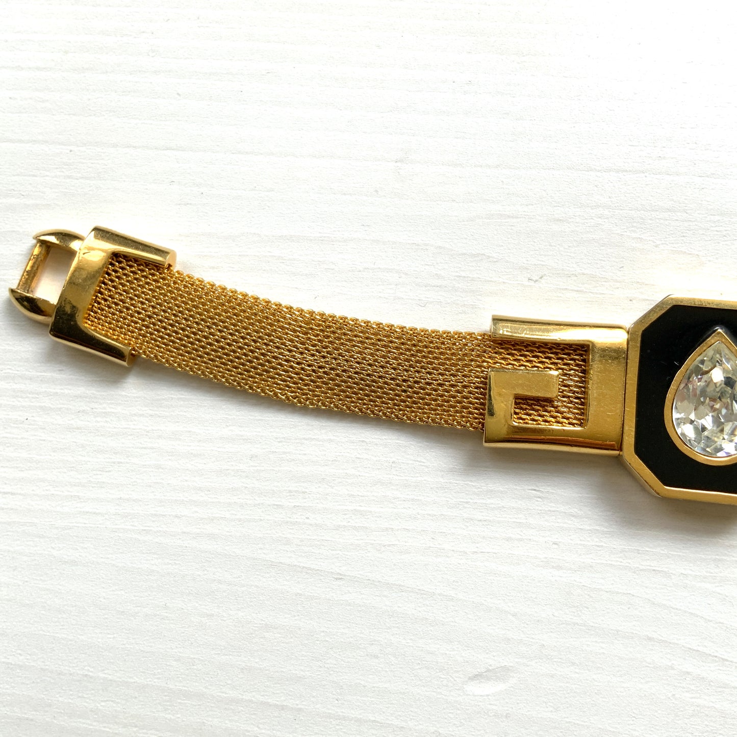 A Givenchy bracelet featuring black enamel, a teardrop of clear rhinestones, and the brand’s initial “G” logo. 黒のエナメルにクリアラインストーンのティアドロップ、そしてブランドロゴのイニシャル”G"が入った、ジバンシィのブレスレット。
