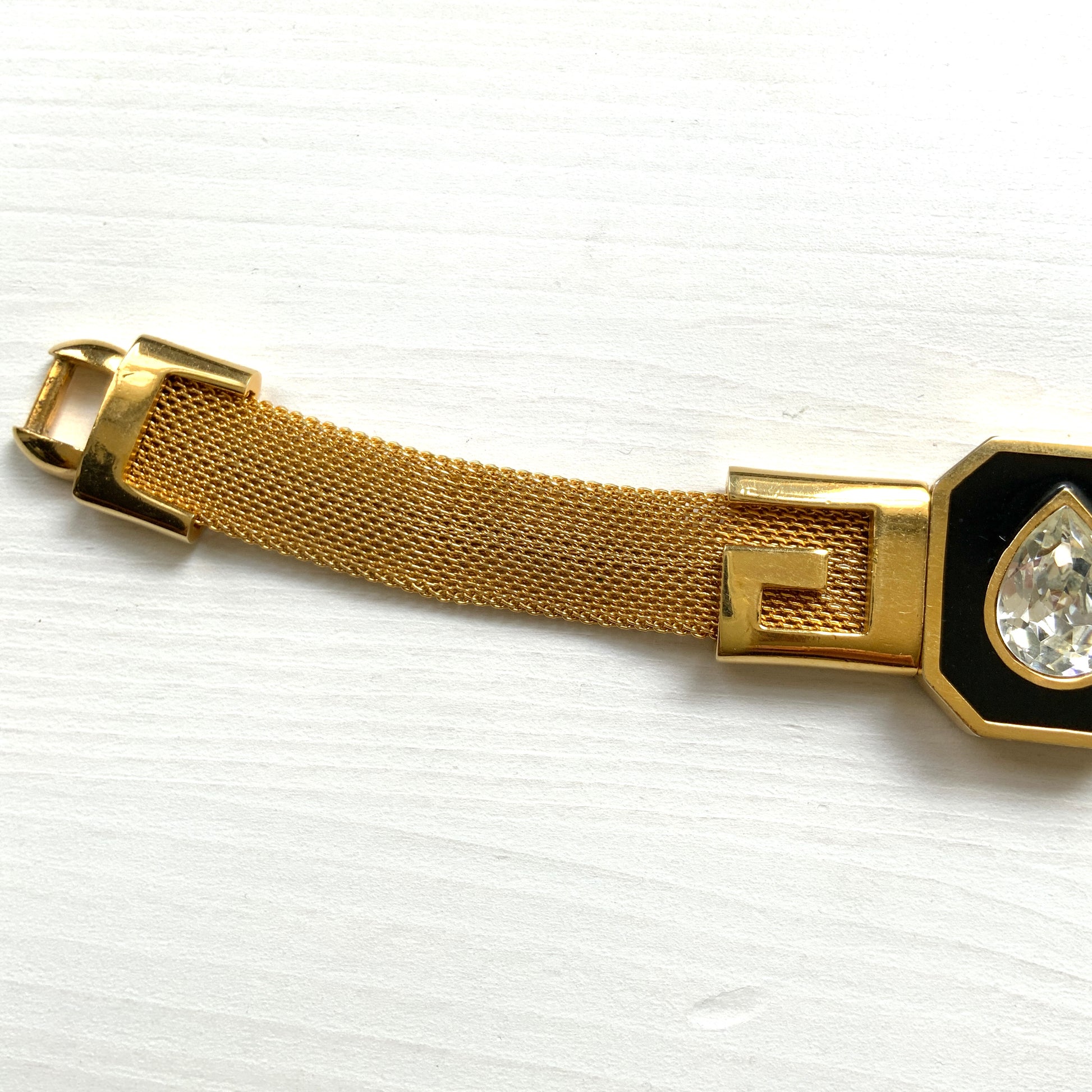 A Givenchy bracelet featuring black enamel, a teardrop of clear rhinestones, and the brand’s initial “G” logo. 黒のエナメルにクリアラインストーンのティアドロップ、そしてブランドロゴのイニシャル”G"が入った、ジバンシィのブレスレット。