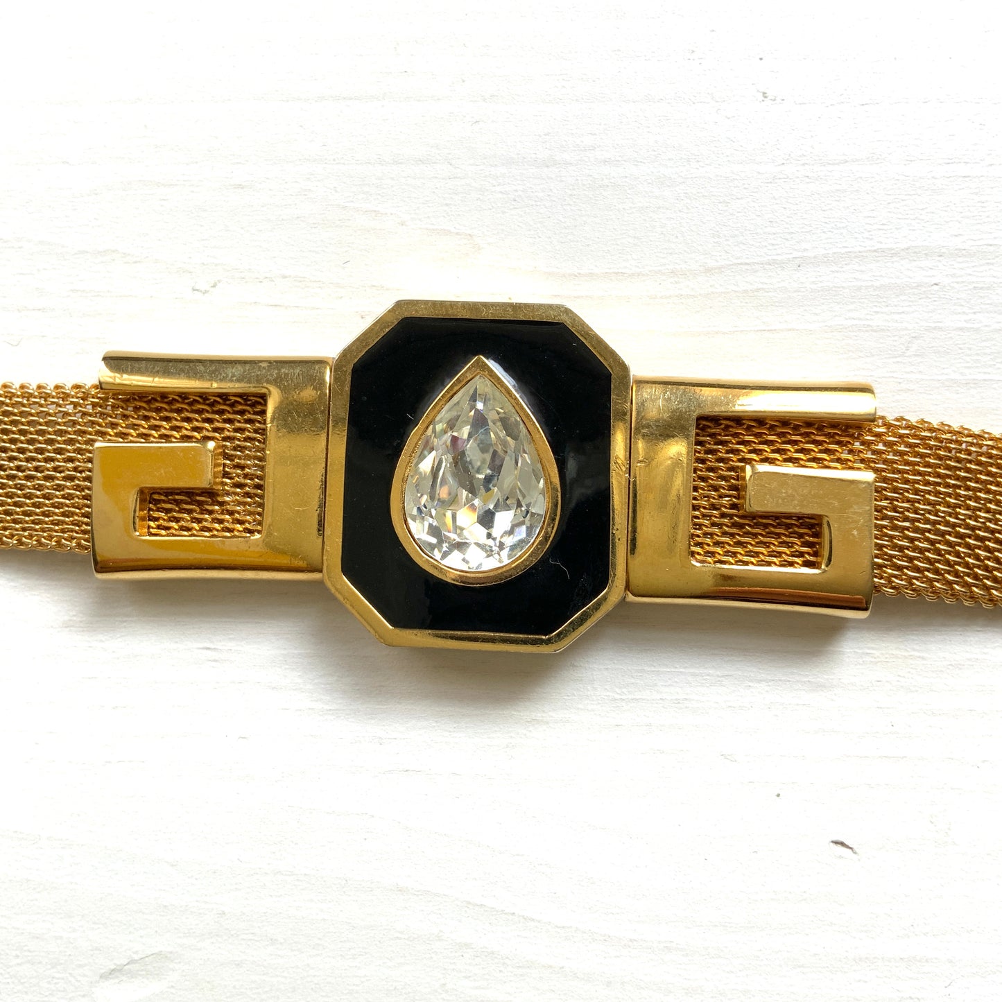 A Givenchy bracelet featuring black enamel, a teardrop of clear rhinestones, and the brand’s initial “G” logo. 黒のエナメルにクリアラインストーンのティアドロップ、そしてブランドロゴのイニシャル”G"が入った、ジバンシィのブレスレット。