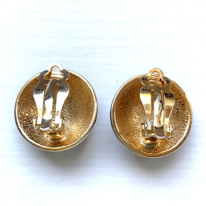 Clip-on earrings featuring a vibrant blue enamel dome, with silver-tone crescent moon faces and stars floating across the surface. 鮮やかなブルーエナメルのドームに、シルバートーンの三日月ムーンフェイスや星が浮かんだクリップイヤリング。