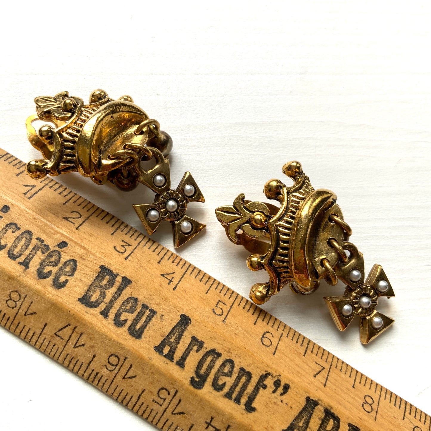 Gold-tone crown clip-on earrings with a Maltese cross charm. ゴールドトーンのクラウンに、マルティーズクロスがゆれるクリップイヤリング。 