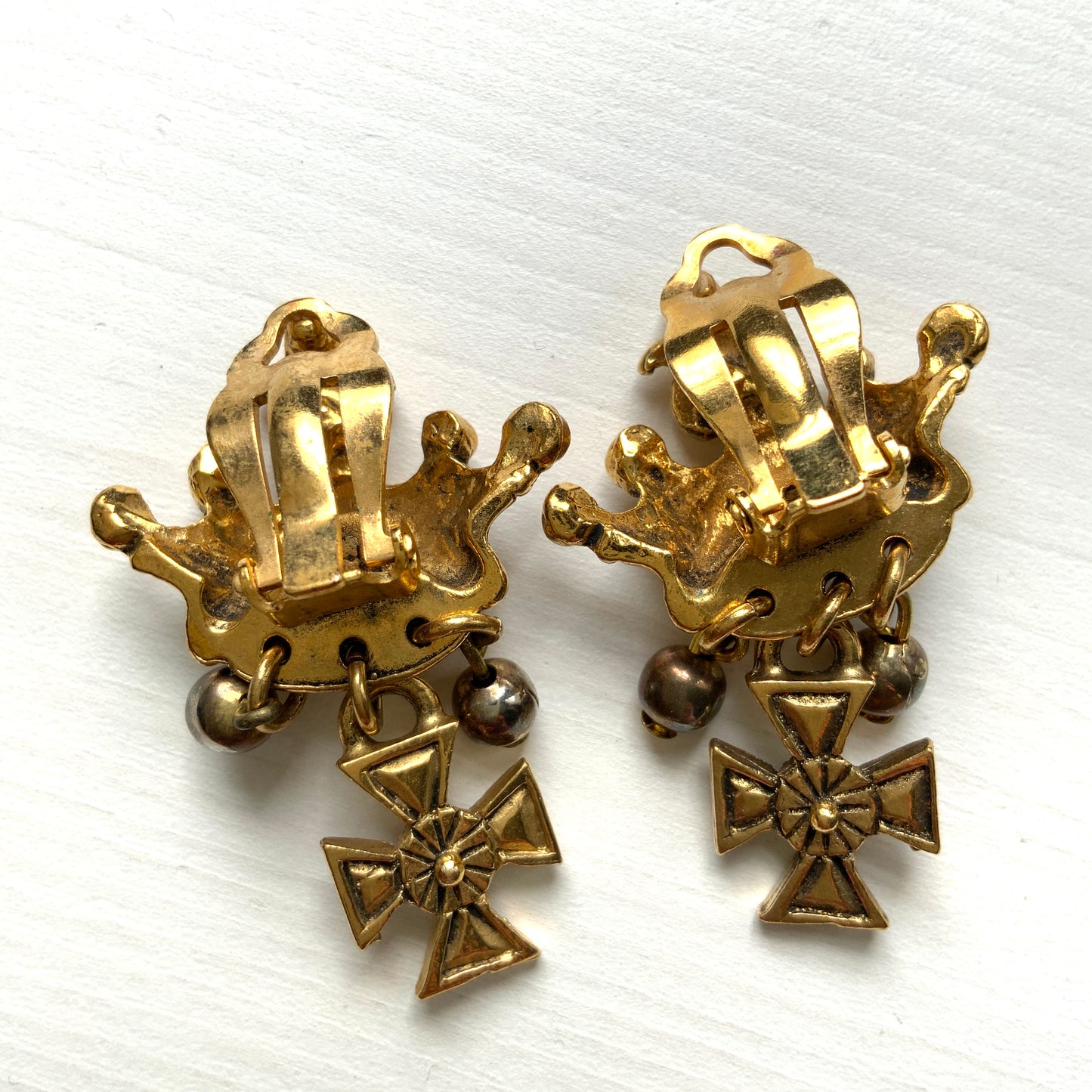 Gold-tone crown clip-on earrings with a Maltese cross charm. ゴールドトーンのクラウンに、マルティーズクロスがゆれるクリップイヤリング。 