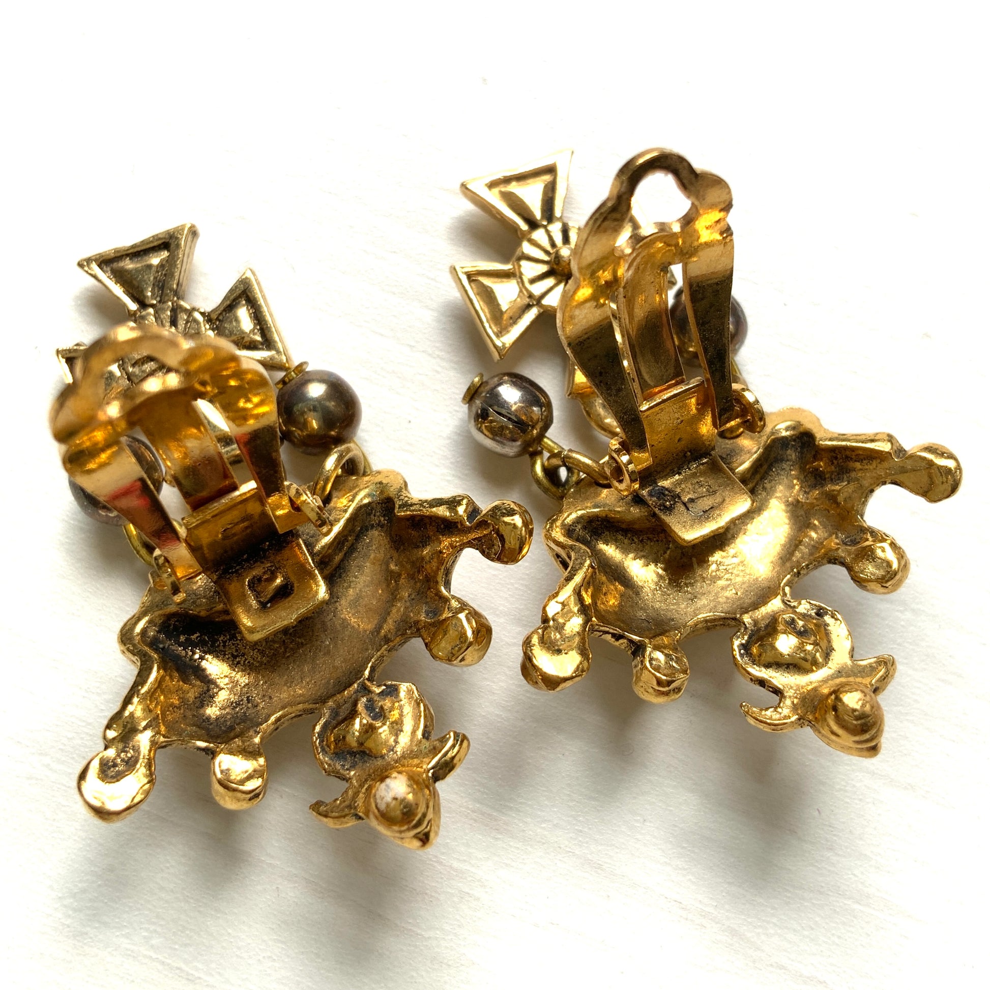 Gold-tone crown clip-on earrings with a Maltese cross charm. ゴールドトーンのクラウンに、マルティーズクロスがゆれるクリップイヤリング。 