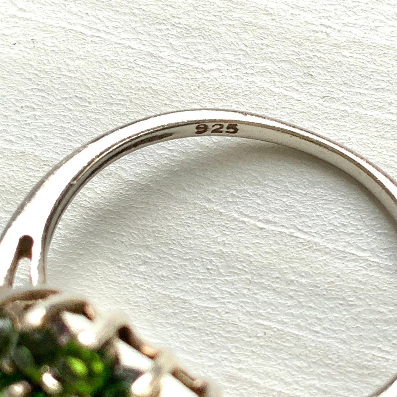 A silver ring set with vivid green diopside stones arranged in a floral design. 鮮やかなグリーンのダイオブサイドが花のように並んだシルバーリング。 