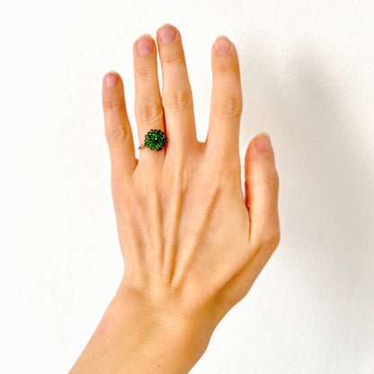 A silver ring set with vivid green diopside stones arranged in a floral design. 鮮やかなグリーンのダイオブサイドが花のように並んだシルバーリング。 