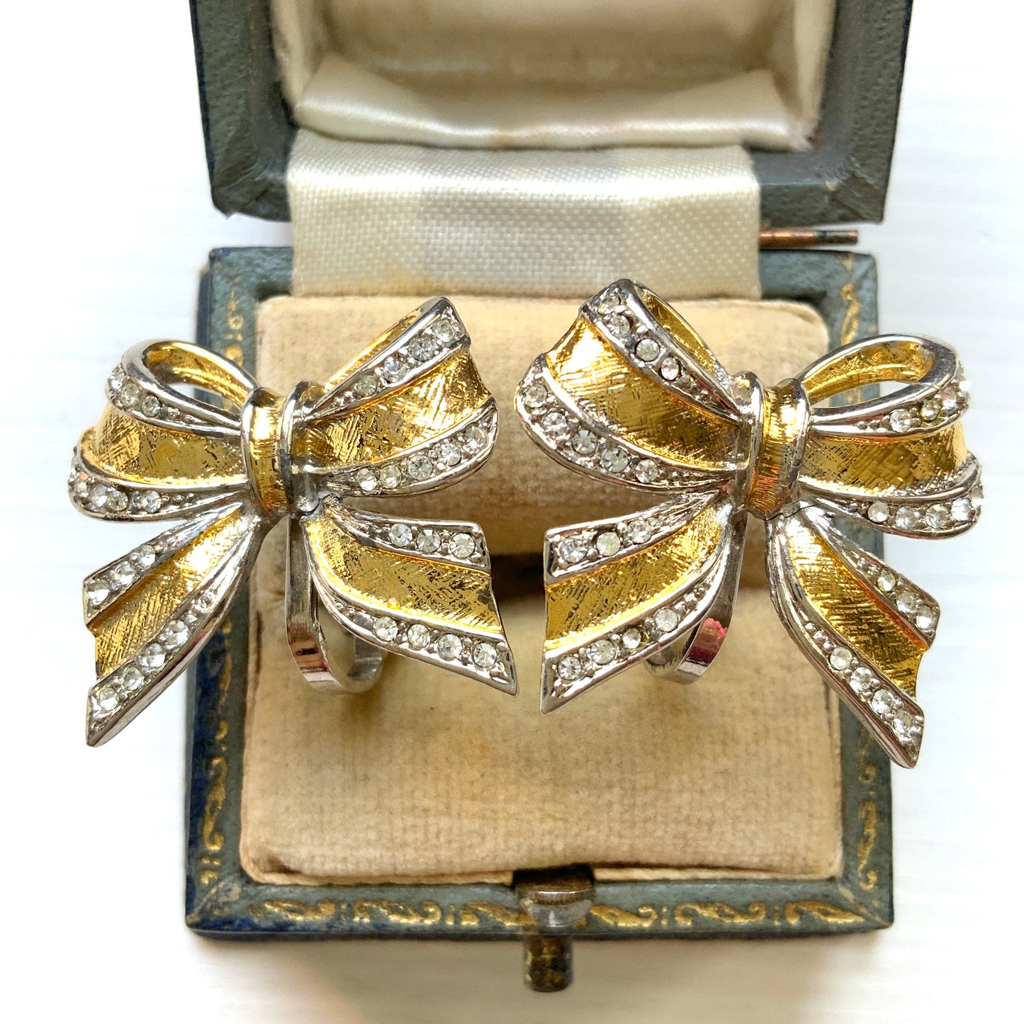 Vintage clip-on earrings in a bow design featuring both gold-tone and silver-tone metal. ゴールドトーンとシルバートーンのリボンのクリップイヤリング。 