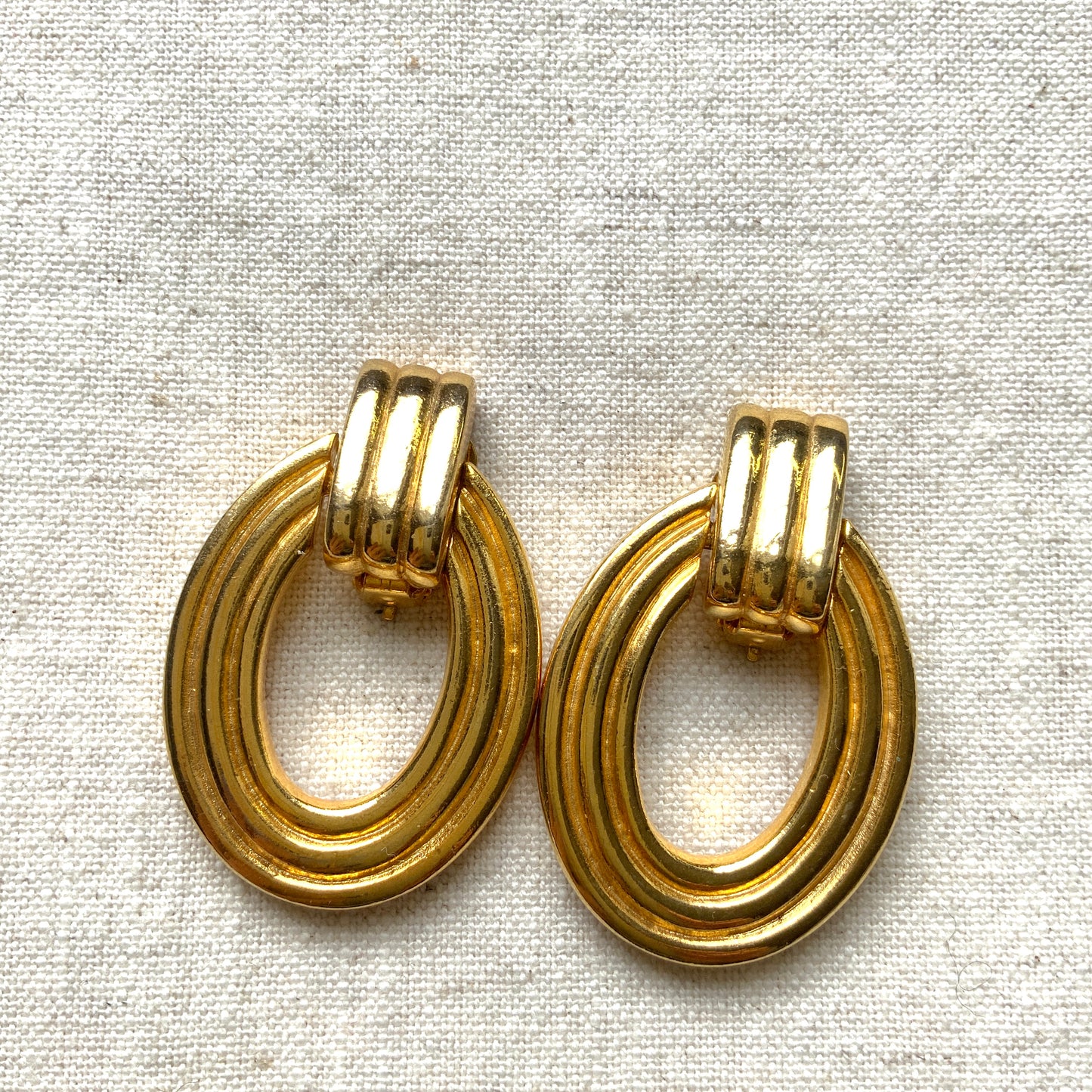 Gold-tone door knocker earrings with subtle linear detailing. ラインが入ったゴールドトーンのドアノッカーイヤリング。 