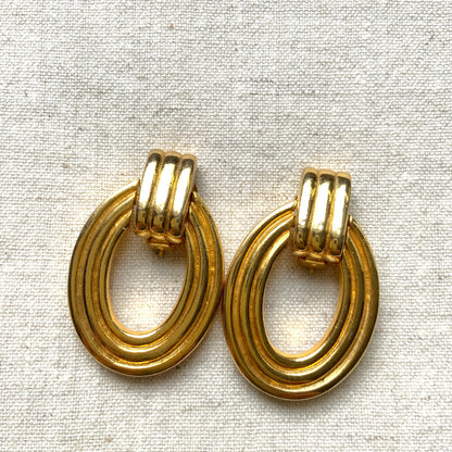 Gold-tone door knocker earrings with subtle linear detailing. ラインが入ったゴールドトーンのドアノッカーイヤリング。 