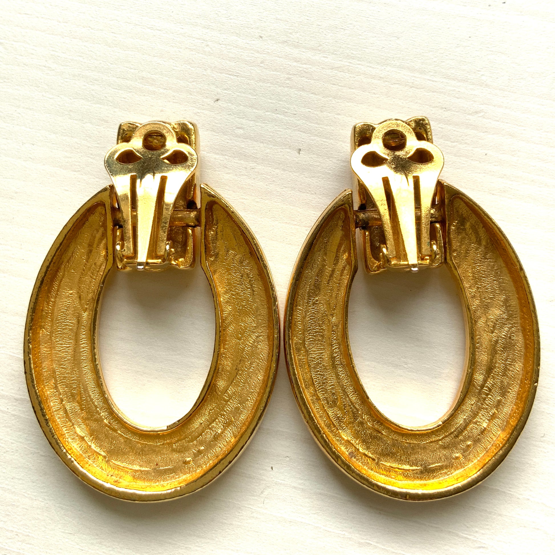 Gold-tone door knocker earrings with subtle linear detailing. ラインが入ったゴールドトーンのドアノッカーイヤリング。 