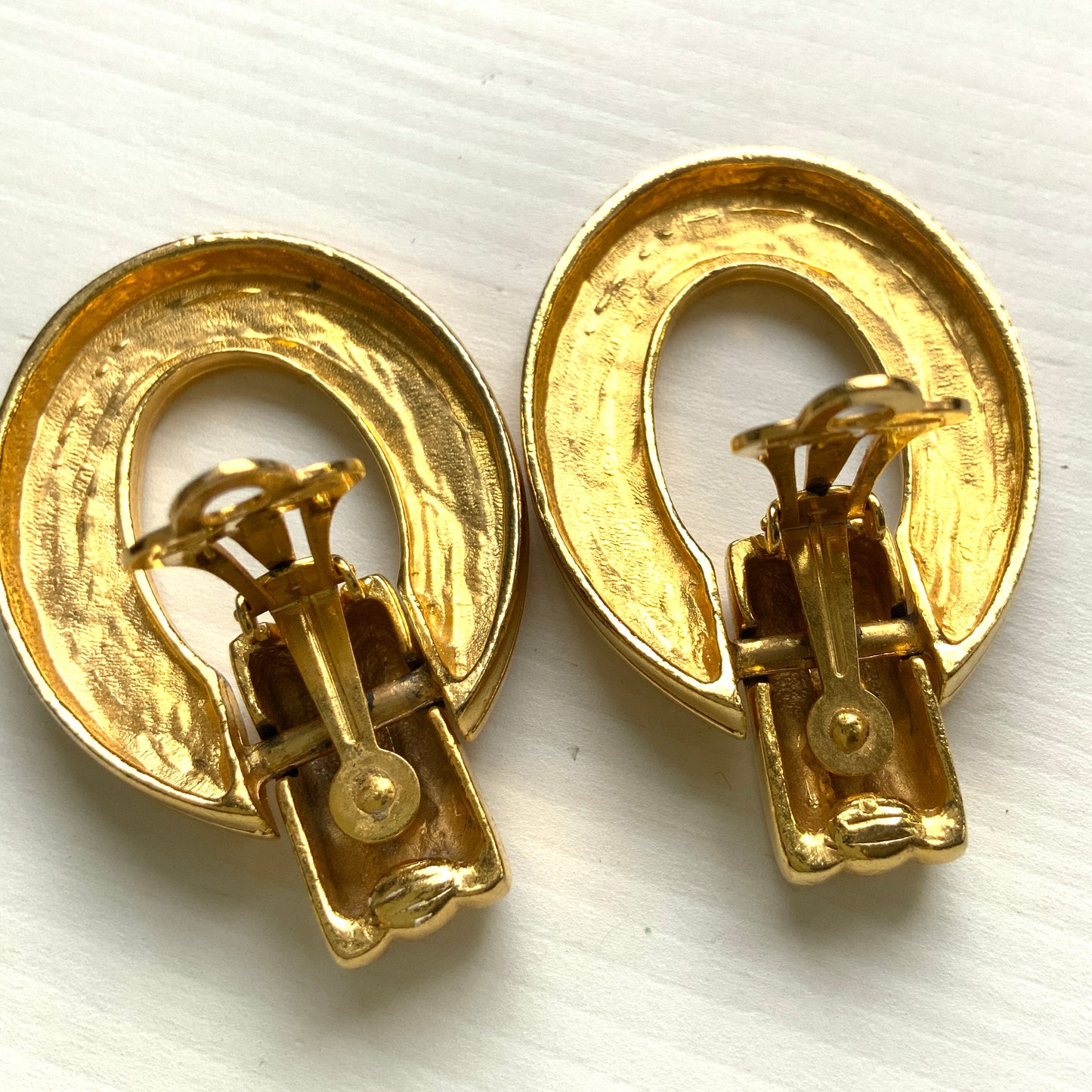 Gold-tone door knocker earrings with subtle linear detailing. ラインが入ったゴールドトーンのドアノッカーイヤリング。 